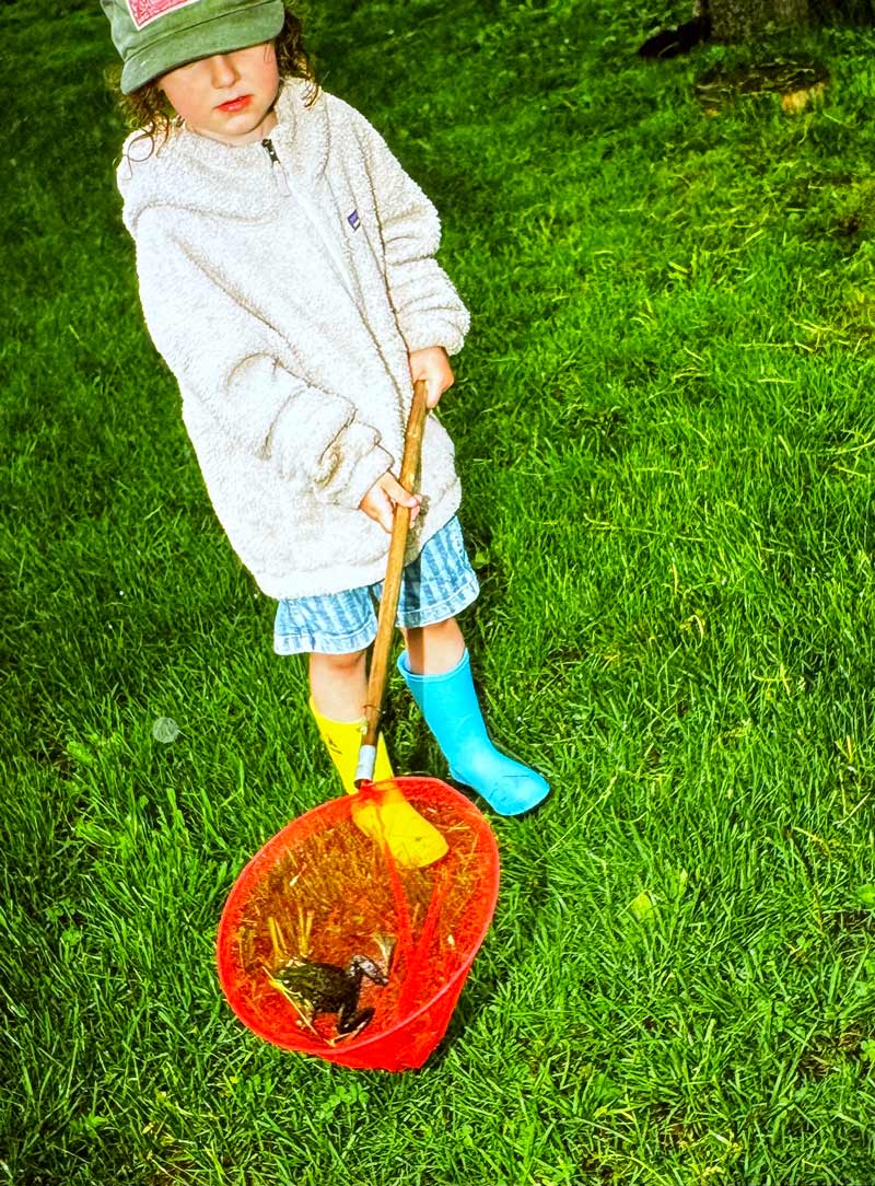 Kid catches a frog while wearing Kamik Stomp rainboots