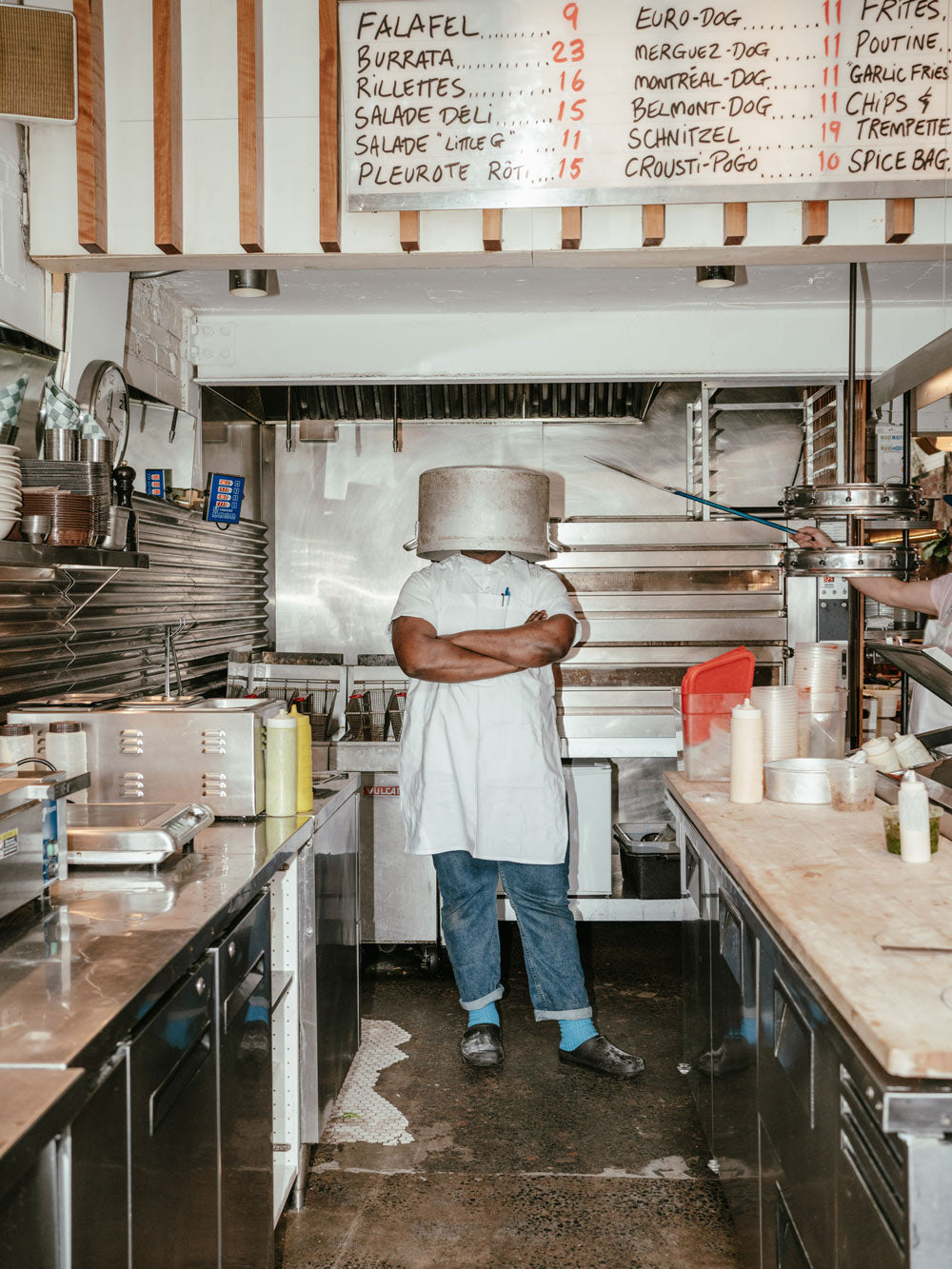 Man with a pot in his head, wearing Kamik Nova clogs during kitchen work shift